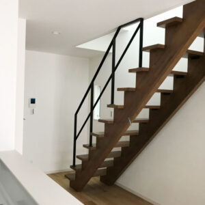 木製のストリップ階段と真っ白なクロスと黒いスチール手すり