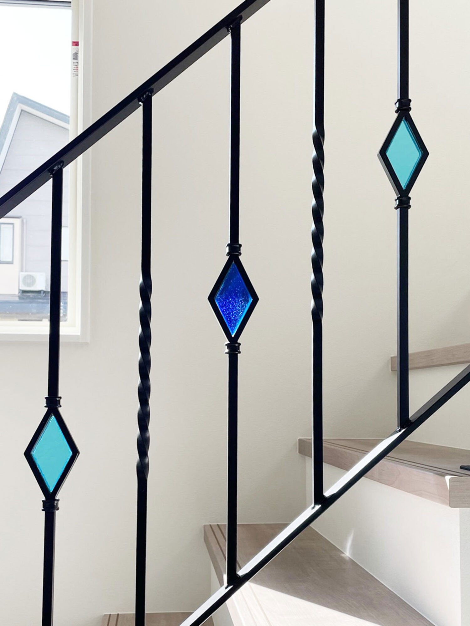 光が差し込んで輝くステンドグラス手すり