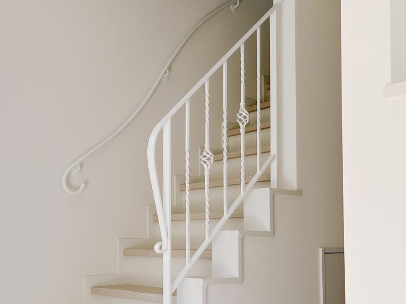 階段と壁付けの２種類の白いアイアン手すりの調和