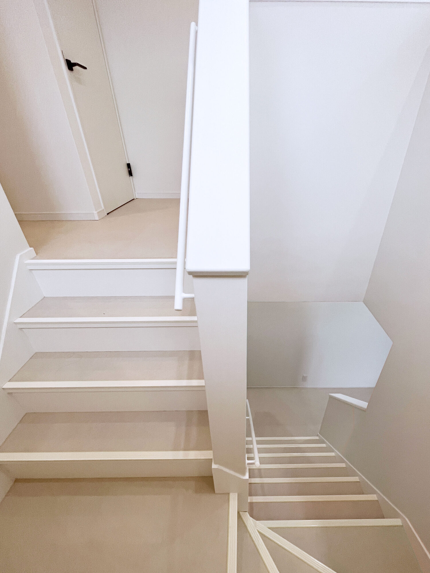 回り階段の内壁に白いアイアン手すり