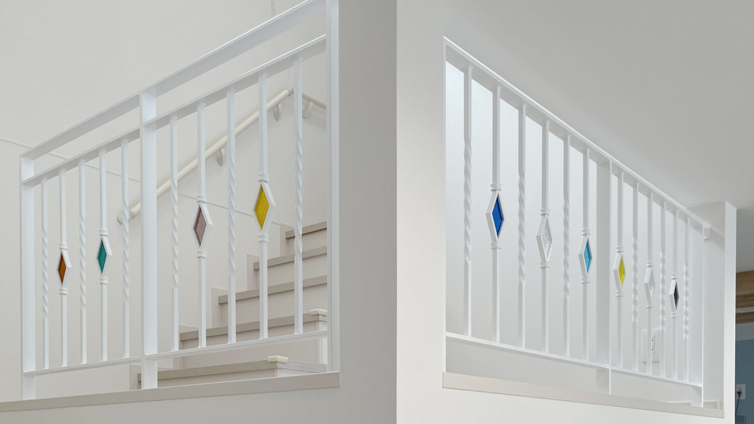 スキップフロアに取り付けたステンドグラス入りの白いアイアン手すり