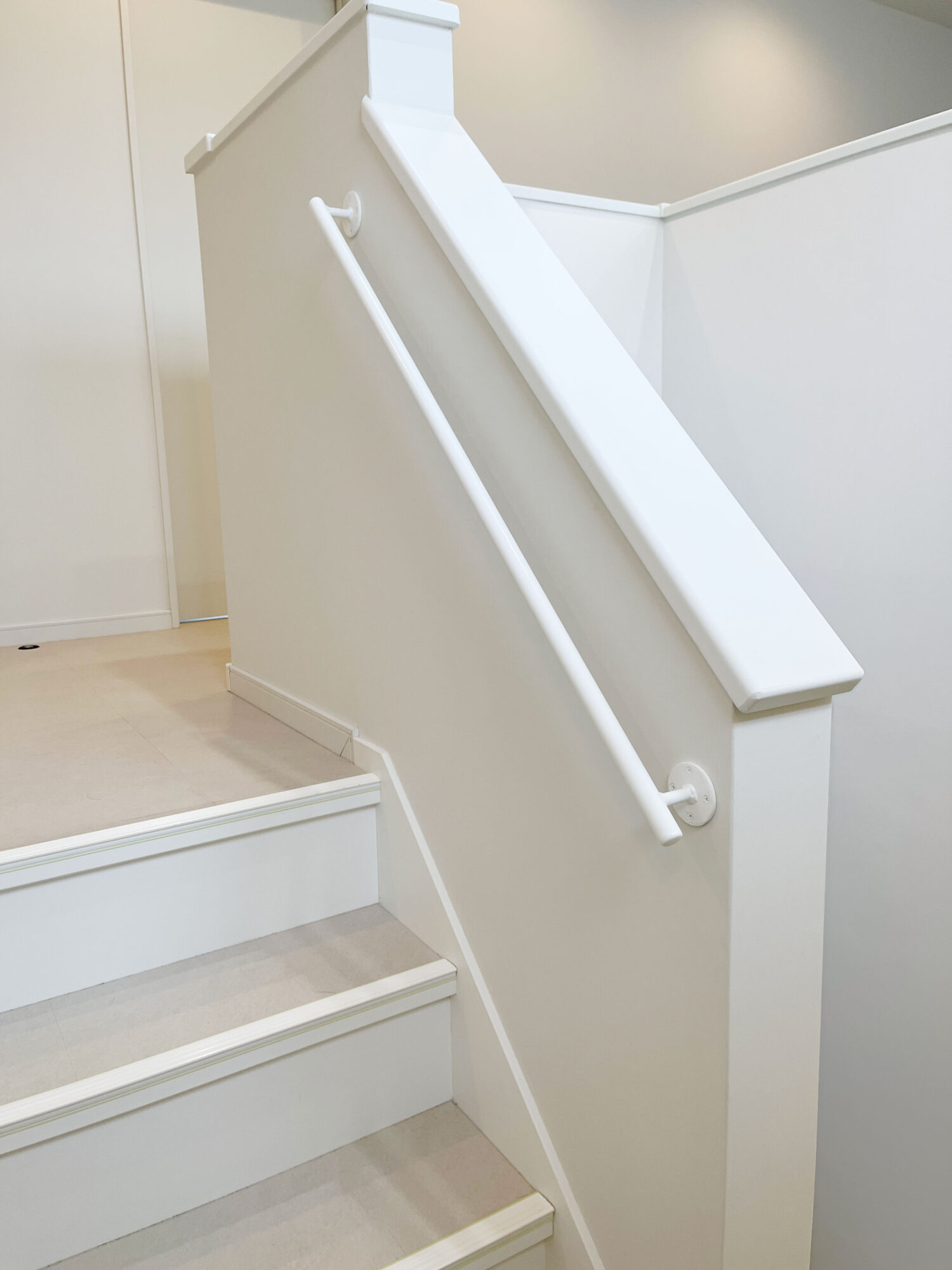 留め具もシンプルな白いアイアン手すり